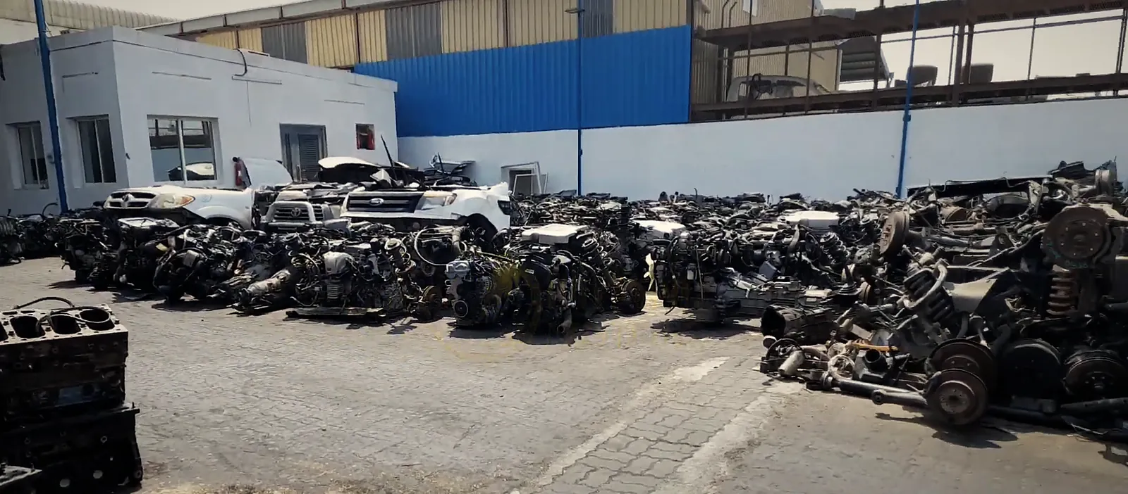 The Miami Motors yard in Industrial Area 3, Sharjah: rows of engines and half cuts outside the shed
